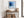 Black-framed blue abstract print above a rustic console table with woven baskets.