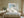 Pale blue coastal abstract in a light wood frame centered above a bed.