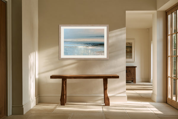 Pale blue coastal abstract in a light wood frame above a rustic wooden console table.