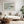 Pale Estuary, matted in a light wood frame, displayed above a white sofa and round coffee table.