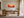 White-framed layered dune artwork above a wooden desk beside tall glass doors.