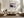 Framed grey, charcoal, beige, and white abstract artwork above a cream sectional sofa.