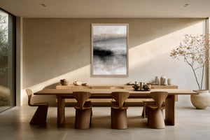 Framed abstract landscape above a long wooden dining table with sculptural chairs.