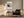 Framed abstract landscape above a dark armchair, side table, and floor lamp.