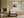 Framed abstract landscape above a cream sofa and wooden coffee table near large windows.