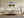 Framed mountain lake artwork above a cream sectional sofa and low wood coffee table.