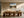 Framed mountain lake artwork above a long wooden dining table with sculptural chairs.