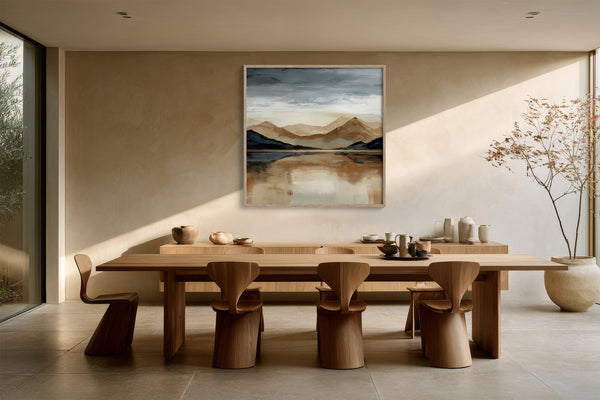 Framed mountain lake artwork above a long wooden dining table with sculptural chairs.