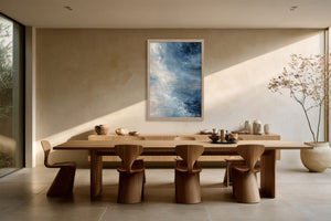 Blue and white abstract artwork above a long wooden dining table with sculptural chairs.