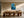 Framed blue glacial river artwork above a long wooden dining table with sculptural chairs.