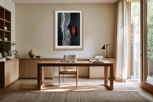 Light-framed aerial shoreline artwork with a red rowing boat above a wooden desk.
