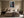 Light-framed aerial shoreline artwork with a red rowing boat above a bed.