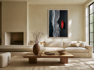 Light-framed aerial shoreline artwork with a red rowing boat above a sofa.