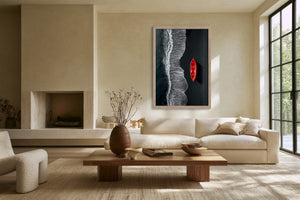 Light-framed aerial shoreline artwork with a red rowing boat above a sofa.