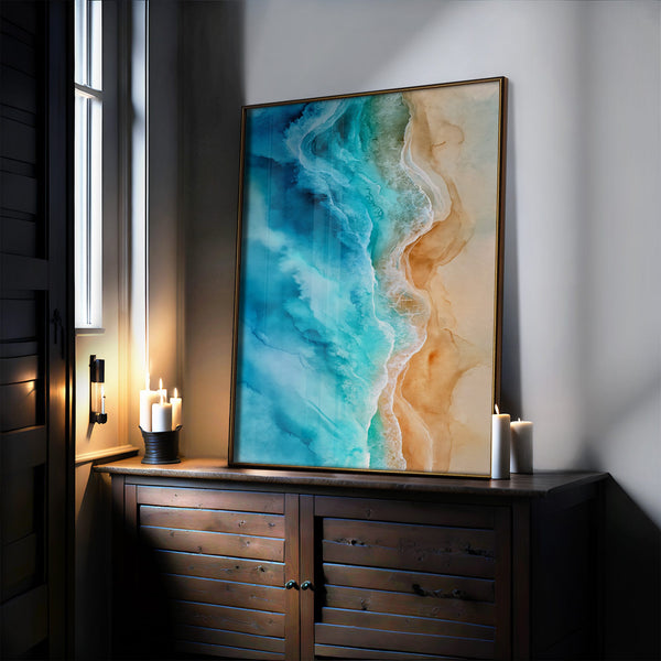Large thin-framed coastal artwork leaning on a dark wood cabinet beside lit candles.