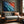 Ember Tide coastal artwork in a dark wood frame above a gray wooden sofa.