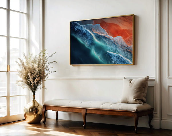 Ember Tide artwork in a thin wood frame above a bench and gold vase of branches.