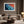Ember Tide print in a light wood frame above a cream sofa, with a floor lamp nearby.