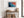 Ember Tide print in a light wood frame above a rustic console with woven baskets.
