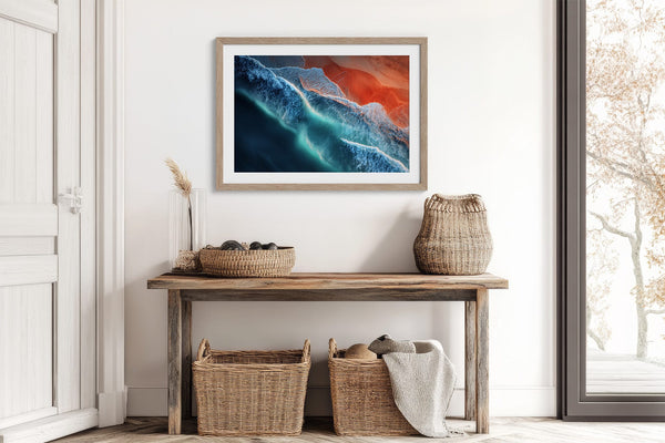 Ember Tide print in a light wood frame above a rustic console with woven baskets.