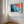 Close wall view of Ember Tide coastal artwork in a light wood frame with white matting.