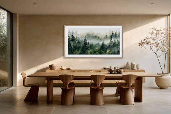 Framed misty pine forest watercolor displayed above a long wooden dining table and sculptural chairs.
