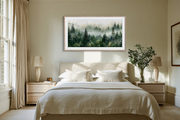 Misty pine forest watercolor in a light wood frame above a white bed between matching nightstands.