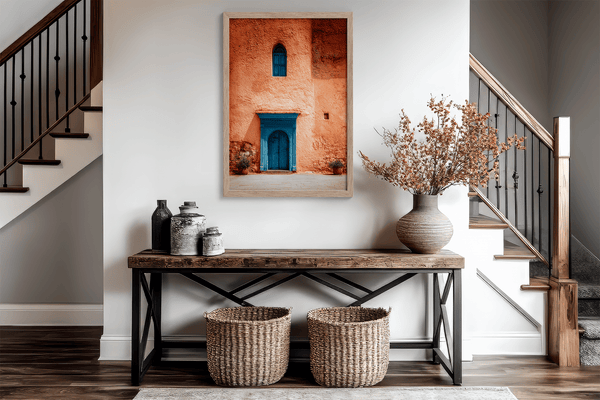 Framed Moroccan street scene art print featuring a vivid blue doorway and ochre wall. A soulful, timeless piece for eclectic interiors.
