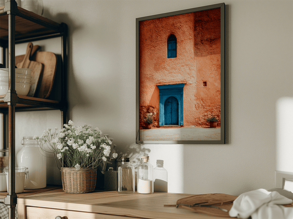 Framed Moroccan street scene art print featuring a vivid blue doorway and ochre wall. A soulful, timeless piece for eclectic interiors.