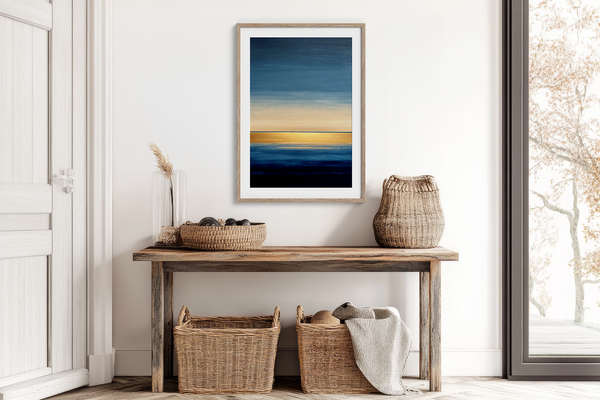 Framed wall art of an abstract seascape in deep indigo, blue, and gold. A minimalist horizon print evoking calm and renewal.