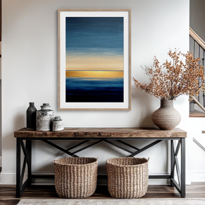 Framed wall art of an abstract seascape in deep indigo, blue, and gold. A minimalist horizon print evoking calm and renewal.