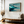 Framed wall art of abstract ocean waves in deep indigo, teal, and white. A calming coastal piece that’s ready to hang.