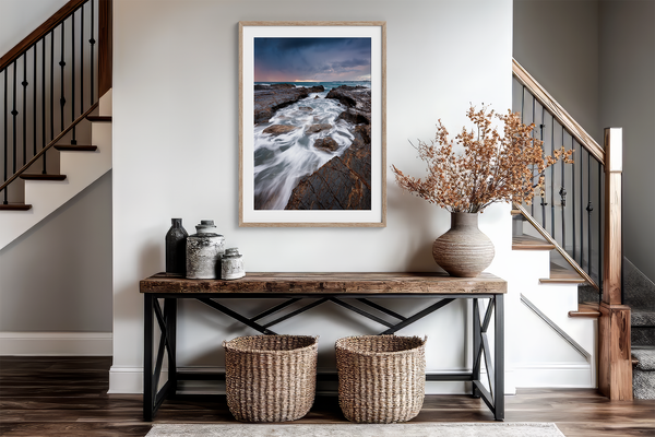 Framed wall art of the Australian coast with rugged rocks, azure sea, and moody skies. A striking coastal landscape print. Ready to hang.