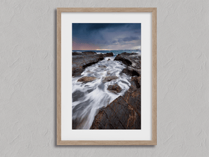 Framed Australian coastal wall art print with rugged rocks and deep blue sea