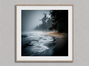 Framed misty beach wall art print with waves, dark sand and pines in fog