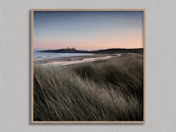Serene Northumberland Castle at sunset with seagrass and tidal reflections — a tranquil wall art print for peaceful, coastal-inspired interiors.