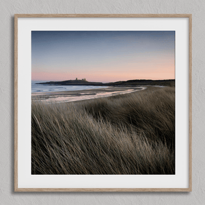 Serene Northumberland Castle at sunset with seagrass and tidal reflections — a tranquil wall art print for peaceful, coastal-inspired interiors.