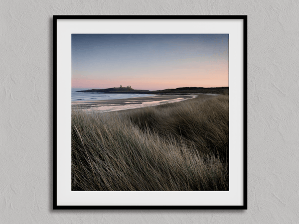 Serene Northumberland Castle at sunset with seagrass and tidal reflections — a tranquil wall art print for peaceful, coastal-inspired interiors.