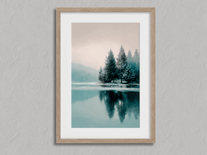 Framed winter lake wall art print with frosted evergreens and island reflections