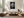 Framed black-and-white rain-covered leaf artwork above a low cream sectional and wooden coffee table.