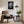 Framed black-and-white wet leaf artwork above an upholstered armchair and side table.