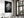 Large black-framed wet leaf photograph above a set dining table beside tall windows.