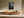 Framed black-and-white leaf vein photograph above a low wooden sideboard with ceramic objects.