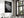 Framed black-and-white dew-covered leaf wall art displayed above a set dining table near tall windows.