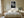 Light-framed dew-covered leaf wall art centered above a bed with white bedding and bedside tables.