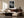 Light-framed dew-covered leaf wall art above a curved sofa and dark wooden sideboard.