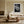 Light wood-framed dew-covered leaf wall art above a cream sofa and low wooden coffee table.