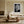 White-matted monochrome leaf artwork in a light wood frame above a cream sofa.
