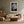 White-matted black-and-white leaf print centered above a cream sofa and wood coffee table.