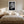 White-matted monochrome leaf artwork above a bed between matching bedside lamps.